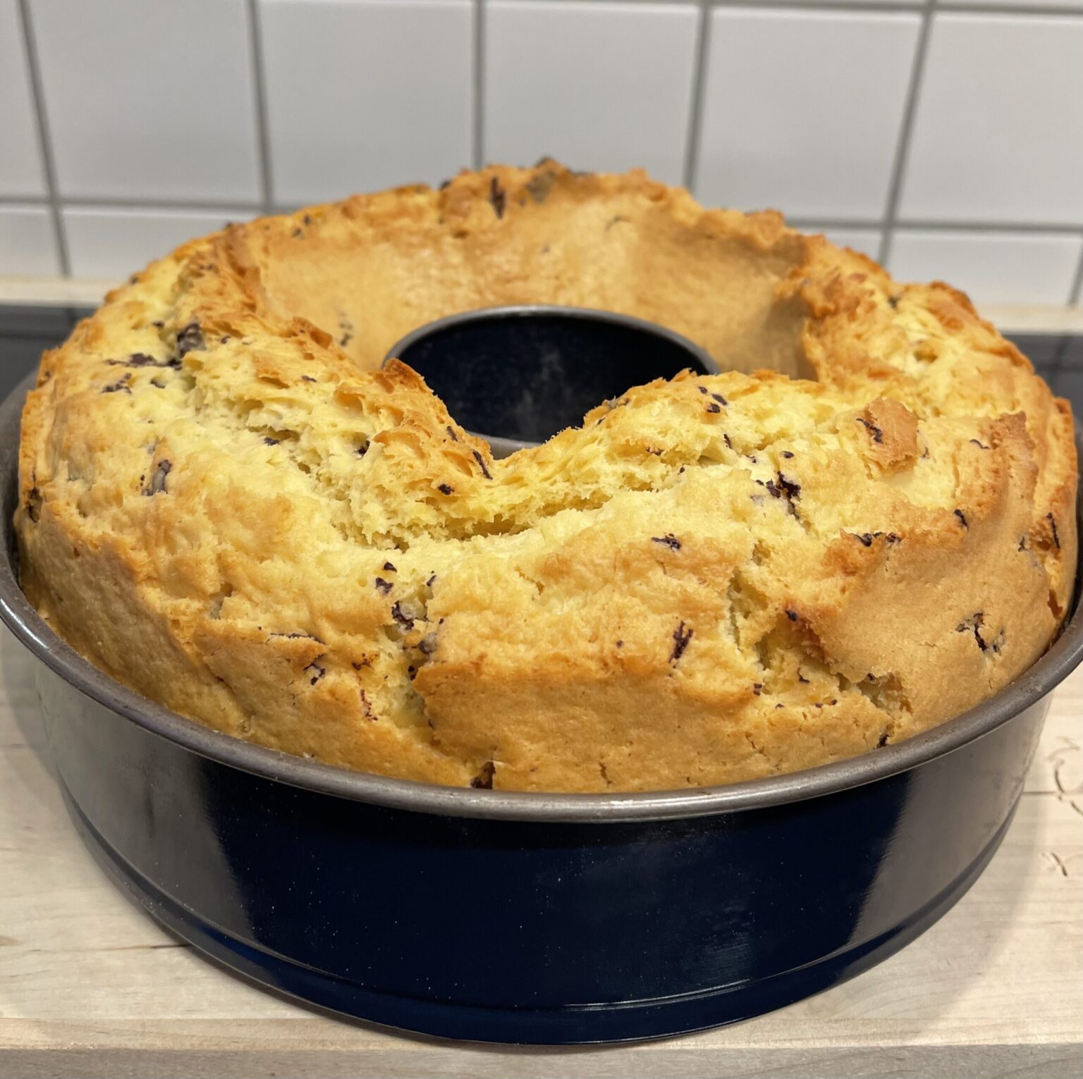 Freshly baked Selterskuchen with a golden, cracked crust and chocolate pieces, still in its blue Bundt pan.
